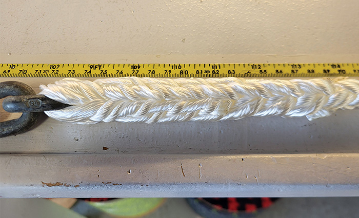 A white splice being measured by a yellow tape measure.