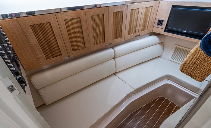 Overhead view showing a boat's cabin with wood cabinets, television and seating area.