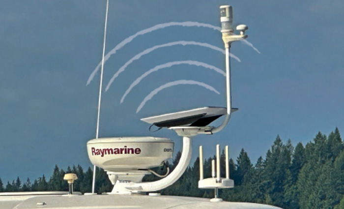 A Raymarine satellite  mounted on top of a white vessel with blue skies and green trees in the background. 