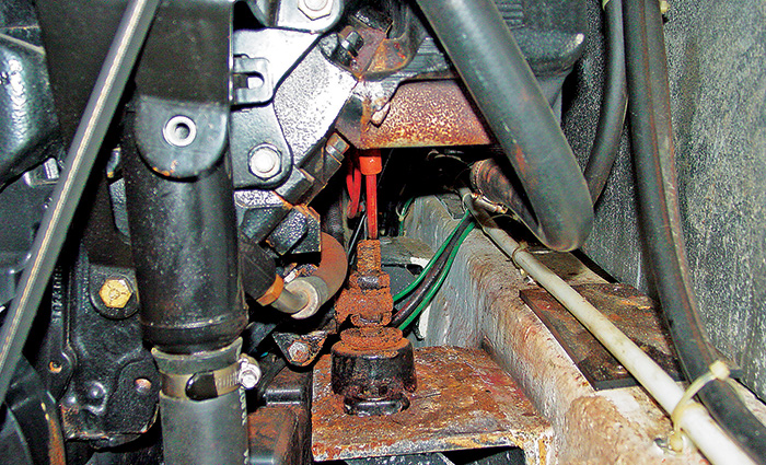 Black engine mount covered in orangish/red rust.