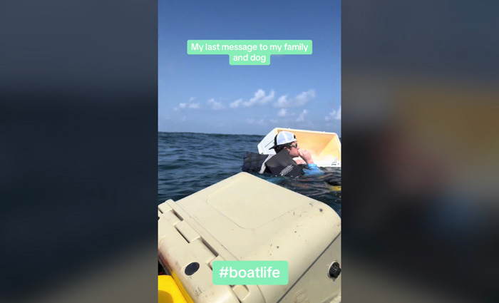 Adult male wearing backwards hat and sunglasses floating in open sea water amongst cooler and other items.