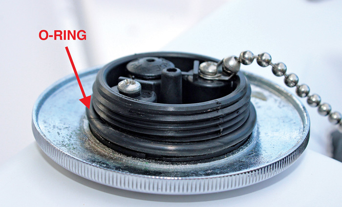 Up-close view of a fuel cap with red arrow pointing out the o-ring.