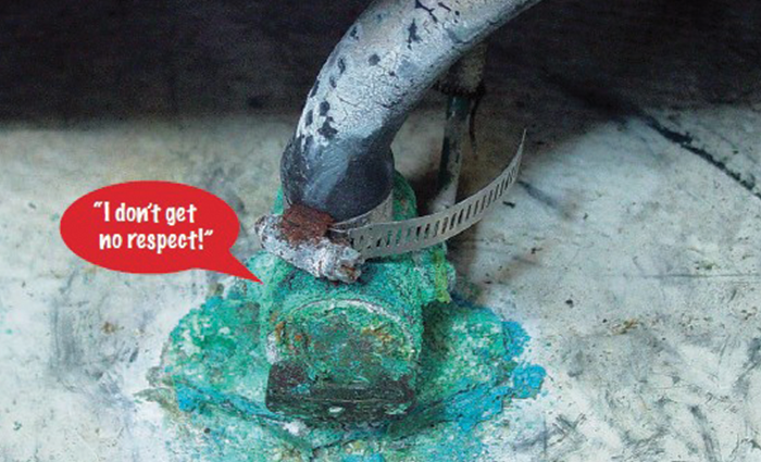 An old and worn seacock with rust and discoloration around the valve.