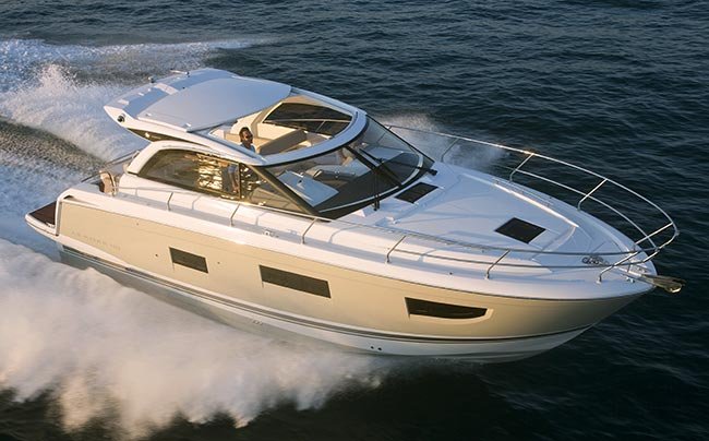 a large powerboat is underway with white spray coming off the back of the boat