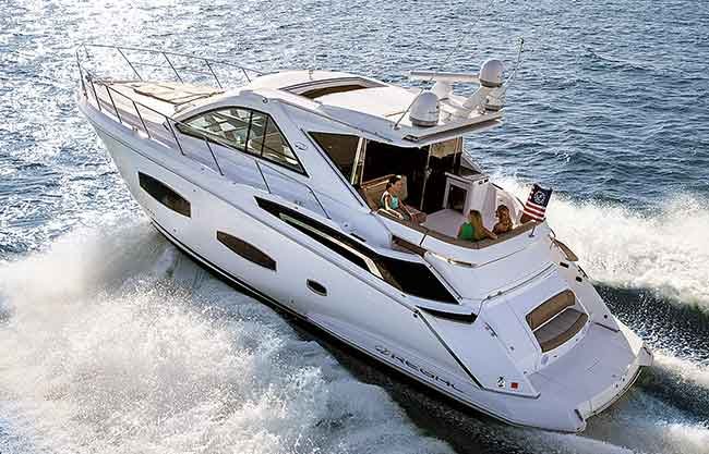 Ariel view of Regal 53 Sport Coupe powerboat underway.  Three woman sit in aft of boat. Red white and blue flag blows off back of boat.